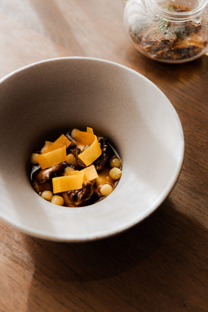 Rolled and shaped by hand daily, our squash anolini is served with baby Jerusalem artichokes, finished in a roasted root vegetable consommé with brown butter and sage.